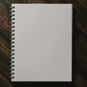 white spiral notebook on brown wooden table